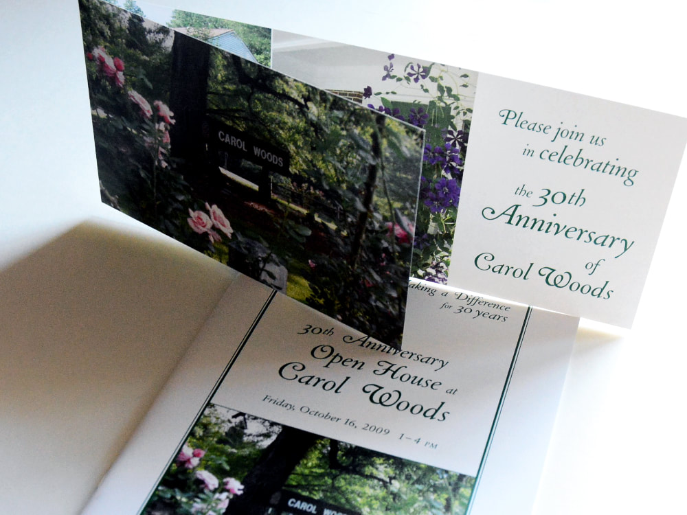Photograph of a folded, horizontal event invitation with a shorter front piece on top of an open house tour booklet. Both items have outdoor photography of the retirement community’s campus and green, curling headline text.